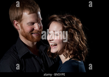 Coppia felice in studio in piedi faccia a faccia ridere Foto Stock