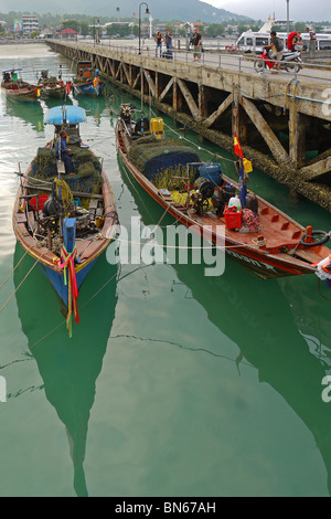 Lunga coda di barche da pesca ormeggiate vicino al molo su Koh Samui, Thailandia Foto Stock