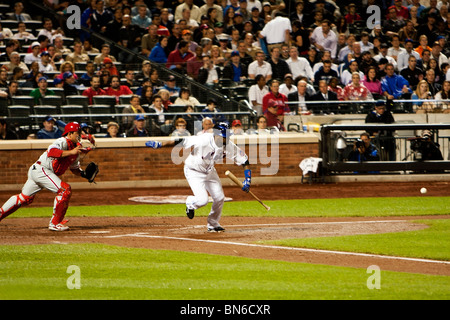 Johan Santana appena colpito batted una sfera ed è in esecuzione per la prima base mentre Carlos Ruiz catcher corre per andare dopo il breve palla. Foto Stock