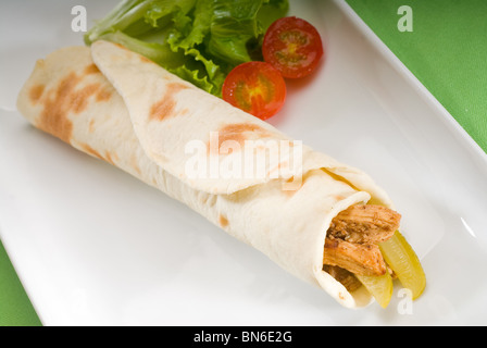 Pane Pita involtini di pollo con sottaceti cetrioli su una piastra con il pomodoro di Pachino e lattuga Foto Stock