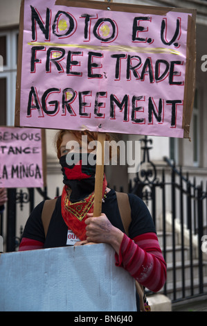 La mobilitazione per la Madre Terra protester con maschera facciale e sulla targhetta No all Unione europea accordo di libero scambio di fronte alla ambasciata colombiana Foto Stock