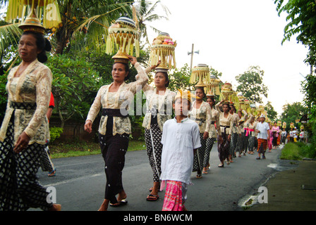 Un tempio Balinese anniversario processione con le donne che trasportano belle offerte per essere lasciato al alter. Sfarzosi costumi. Foto Stock