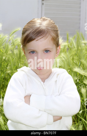 Arrabbiato deluso gesto bambina picchi verde prato giardino Foto Stock