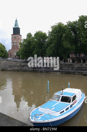 Barca sul fiume Aura, Turku, Finlandia con la Cattedrale luterana in background Foto Stock