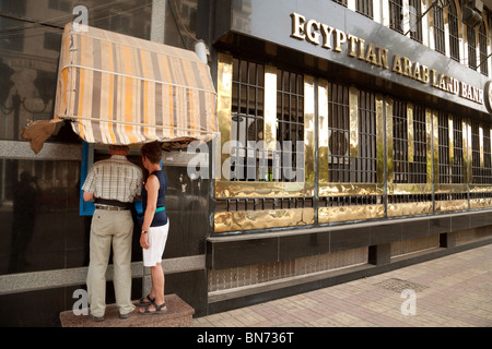 Due turisti ottenere denaro da un bancomat, Egyptian Arab Land Bank, Aswan, Alto Egitto, Africa Foto Stock