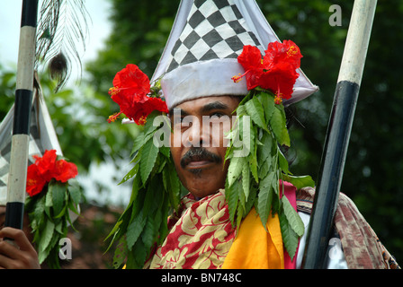 In una cerimonia di cremazione in Sanur, Bali, un gruppo di uomini guidato la processione fino alla spiaggia vestito in costumi elaborati. Foto Stock