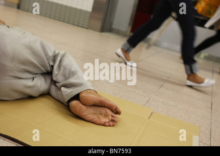 Senzatetto uomini sonno agitato in scatole di cartone per le strade di Tokyo, Giappone. Foto Stock