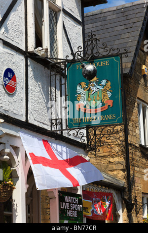 Le tre gru public house segno su un ferro battuto staffa, nel centro del villaggio di Turvey, Bedfordshire, Regno Unito Foto Stock