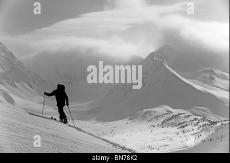 Un backcountry rider scuoiatura in salita in Turnagain Pass, Alaska Foto Stock