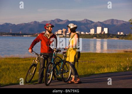 I ciclisti di riposo e di scattare autoritratti lungo il Percorso Costiero di Tony Knowles con ancoraggio in background, Alaska Foto Stock