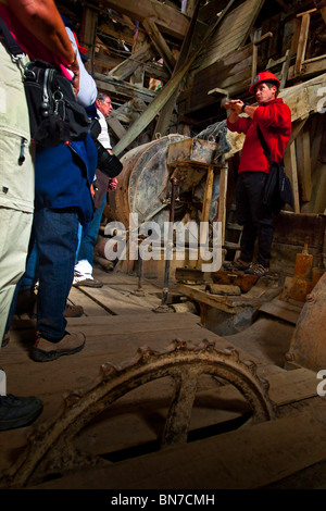 Tour guida mostra ai visitatori il funzionamento del rame antico mulino nel mulino Kennecott Town, Wrangell St. Elias Park, Alaska Foto Stock