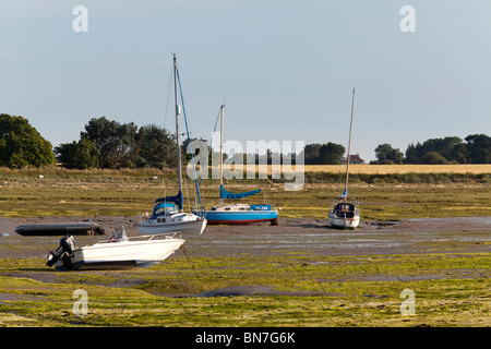 Barche spiaggiata da bassa marea ar Bosham nel porto di Chichester Foto Stock