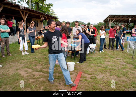 Gettando spugne a persone in stock come team building esercizio Foto Stock