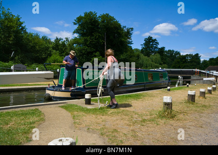 La donna occupare un canale stretto Narrowboat in barca nel blocco Pyrford sul fiume Wey Surrey in Inghilterra Foto Stock