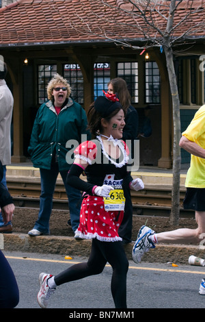 Donna in occhiali da sole reagisce al Maratoneta vestito in un Minnie Mouse costume in Boston. Foto Stock