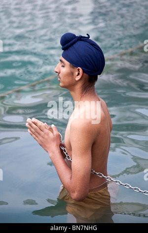 La religione sikh ragazzo che prega in piscina sacra. Il Tempio Dorato. Amritsar. Il Punjab. India Foto Stock