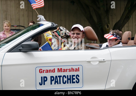 Grand Marshal JP onde patch una bandiera mentre viene guidato lungo il percorso della parata durante il 4 luglio sfilata in Tumwater, WA. Foto Stock