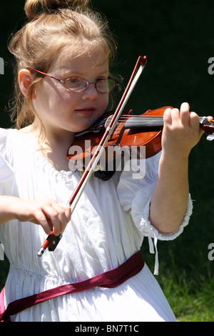 Un bianco giovane ragazza in un abito bianco a suonare il violino Foto Stock