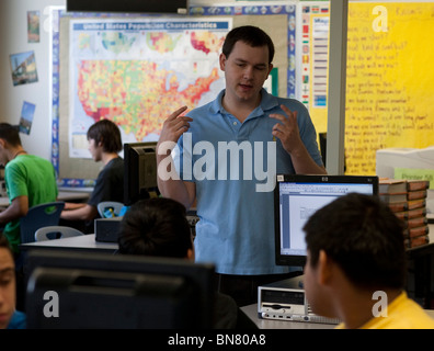 Anglo maschio della High School insegnante di inglese gesti mentre si parla di studente in classe. Foto Stock