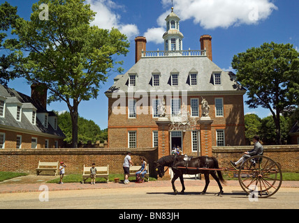 Una carrozza trainata da cavalli passa l'imponente Palazzo del Governatore che risale al 1722 e può essere visitato nella storica coloniale Williamsburg in Virginia, Stati Uniti d'America. Foto Stock