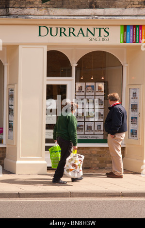 Le persone che visualizzano il Durrants agente immobiliare finestra a Southwold , Suffolk , Inghilterra , Gran Bretagna , Regno Unito Foto Stock