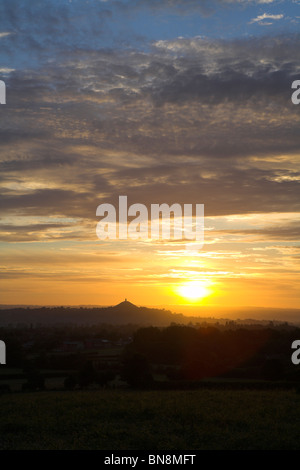 Orange sunrise su Glastonbury Tor in silhouette in giugno. Foto Stock