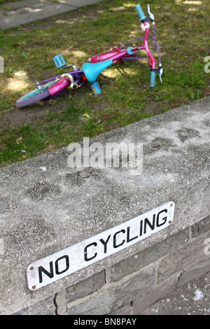 Nessun segno di ciclismo con un bambino abbandonato la bicicletta in background Foto Stock