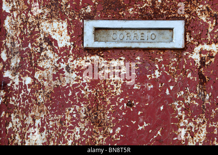 Casella di posta elettronica slot sul vecchio grungy porta in Portogallo Foto Stock
