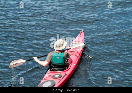 Un uomo in rosso con il kayak. Foto Stock