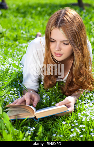 Giovane donna libro lettura in estate park. Foto Stock