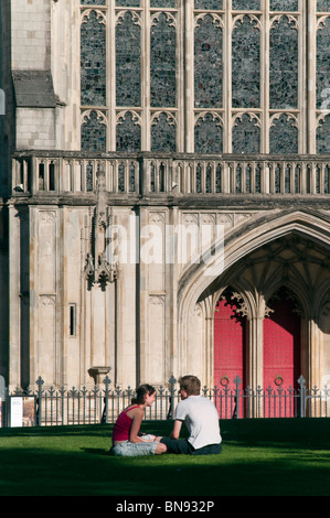 La Cattedrale di Winchester in estate con coppia rilassante sull'erba Nei Dintorni Foto Stock