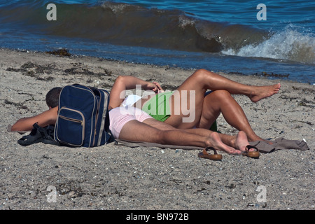 Piccolo uomo e donna di grande sulla spiaggia viaggio. Posizione orizzontale Foto Stock