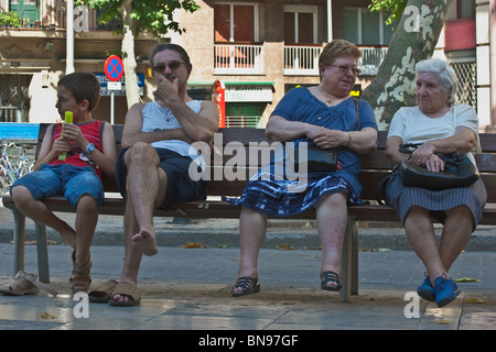 Barcelona, Spagna, Giugno 2009. I cittadini non identificato seduta sul banco di alta avente una conversazione. Foto Stock