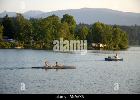 Persone in barca sul lago al tramonto, Murnau am Staffelsee, Garmisch-Partenkirchen, Alta Baviera, Baviera, Germania Foto Stock