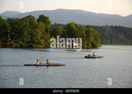 Persone in barca sul lago al tramonto, Murnau am Staffelsee, Garmisch-Partenkirchen, Alta Baviera, Baviera, Germania Foto Stock