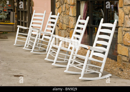 Bianco quattro sedie a dondolo sul marciapiede davanti alla vetrina di Gatlinburg, Tennessee Foto Stock