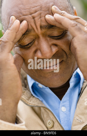 Smorfie razza mista uomo fronte di sfregamento Foto Stock