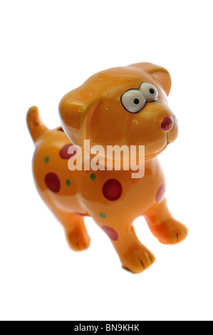 Giallo in miniatura cane in vetro isolato su bianco. Egli ha rosso e macchie di verde Foto Stock