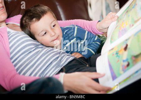 Madre di coricarsi di lettura di storie per bambini Foto Stock