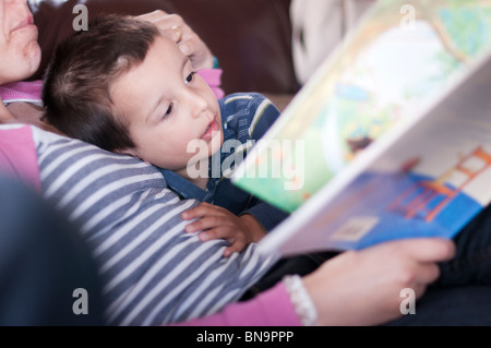 Madre di coricarsi di lettura di storie per bambini Foto Stock