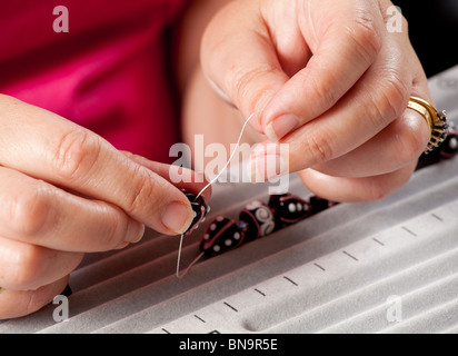 In prossimità dei talloni di filettatura sul filo per rendere cordone artistica collana o bracciale Foto Stock