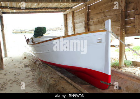 Formentera barca tradizionale arenati su rotaie di legno Foto Stock