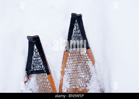 Le punte di una coppia di tradizionali a punta di racchette da neve visibile in fresco in polvere di neve in inverno in Ontario. Foto Stock