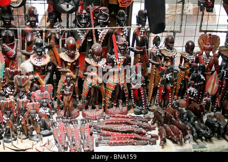 Masai maschere di legno e artigianato tradizionale gli elementi che sono venduti a un negozio di souvenir vicino alla Riserva Nazionale di Masai Mara Kenya, Africa orientale Foto Stock