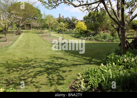 Bluebell Cottage Gardens, Inghilterra. Molla generale vista di Bluebell Cottage Gardens frontiere, arbusti e biancheria da letto. Foto Stock