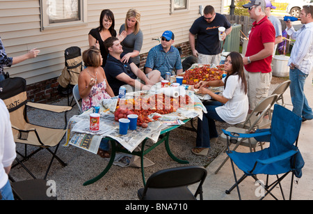 New Orleans, LOUISIANA - marzo 2009 - giovani adulti che mangiano pile di gamberi bolliti alla festa a New Orleans, Louisiana Foto Stock