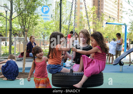 Bambini che giocano su un pneumatico in rotazione un parco in Lower Manhattan. Foto Stock