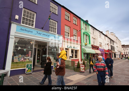 Regno Unito, Galles Gwynedd, Caernarfon, Y Maes, vivaci negozi dipinte di fronte al castello Foto Stock