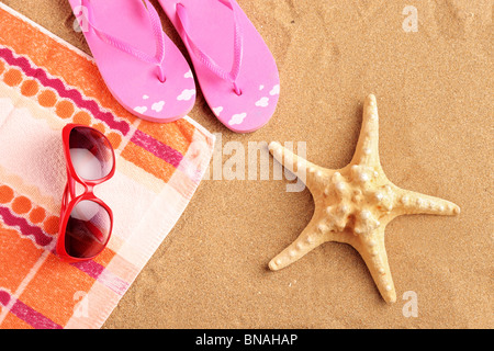 Asciugamano, sandali, occhiali da sole e stelle marine a beach Foto Stock