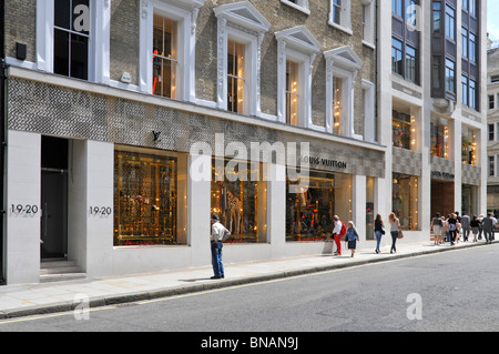 Louis Vuitton davanti al negozio francese di moda di lusso e la finestra decorata mostra il giorno estivo soleggiato in New Bond Street Mayfair West End Londra Inghilterra Regno Unito Foto Stock